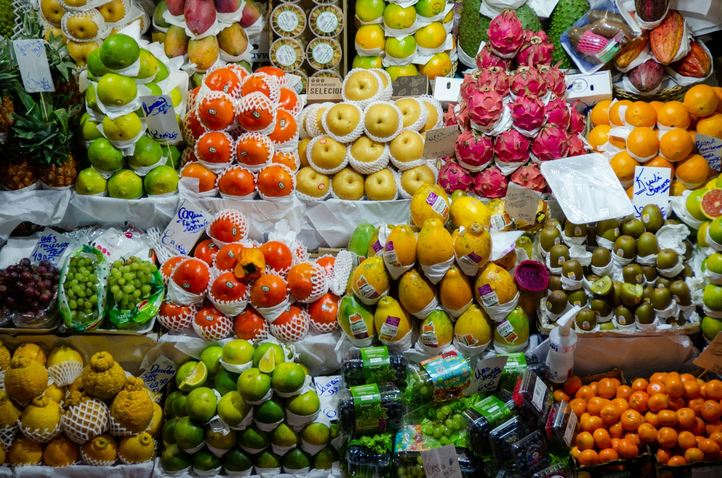 Un puesto de mercado lleno de fruta de colores